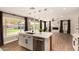 Open kitchen view with island and living room featuring a modern fireplace, backyard view, and wood floors at 7869 W Market St, Glendale, AZ 85303