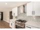 Bright kitchen with stainless steel appliances, white cabinets, quartz counters, tile backsplash and wood floors at 7869 W Market St, Glendale, AZ 85303