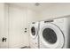 Clean laundry room featuring new, full-sized white washer and dryer units with a white door at 7869 W Market St, Glendale, AZ 85303