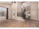 Open-concept living room with soaring ceilings, wood-look tile floors, and modern staircase at 7869 W Market St, Glendale, AZ 85303