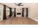 Bright living room with decorative fireplace, ceiling fan, wood floors, and natural light at 7869 W Market St, Glendale, AZ 85303