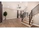 Open-concept living room with soaring ceilings, wood-look tile floors, and modern staircase at 7869 W Market St, Glendale, AZ 85303
