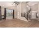 Open-concept living room with soaring ceilings, wood-look tile floors, and modern staircase at 7869 W Market St, Glendale, AZ 85303
