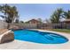 Inviting backyard pool with rock waterfall feature, synthetic turf, and ample space for relaxation at 7869 W Market St, Glendale, AZ 85303