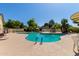 Beautiful community pool area with clear blue water, lounge chairs, and mature trees at 8140 N 107Th Ave # 142, Peoria, AZ 85345