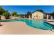 Community pool with lounge chairs, pergola, clear blue water, and a beige surrounding in a gated area at 8140 N 107Th Ave # 142, Peoria, AZ 85345