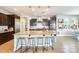 Open kitchen features an island with granite countertops, wooden stools, pendant lights, and modern appliances at 890 W Zion Pl, Chandler, AZ 85248