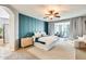 Luxurious bedroom with blue accent wall, ceiling fan, sitting area, and ensuite bathroom at 890 W Zion Pl, Chandler, AZ 85248