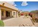 Desert landscaped backyard features a covered patio, mountain views, and colorful flowering plants at 10351 E Morning Star Dr, Scottsdale, AZ 85255