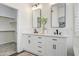 Bathroom featuring double sinks, modern mirrors, neutral walls, and a walk-in closet at 10351 E Morning Star Dr, Scottsdale, AZ 85255