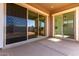 A covered back porch with a concrete floor looks out onto the backyard through sliding glass doors at 11660 W Luxton Ln, Avondale, AZ 85323