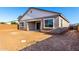 The back of the home features a covered patio and an expansive, empty backyard at 11660 W Luxton Ln, Avondale, AZ 85323