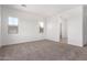 Neutral bedroom with carpet flooring, neutral paint, large windows offering natural light and an open door at 11660 W Luxton Ln, Avondale, AZ 85323