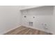 Laundry room with wood flooring, shelving, and laundry hookups, offering convenience and functionality at 11660 W Luxton Ln, Avondale, AZ 85323