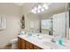 Bright bathroom with double sinks, oak cabinets, and large vanity mirror at 12425 W Jefferson St, Avondale, AZ 85323