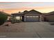 Charming single-story home with desert landscaping and a two-car garage against a vibrant sunset sky at 12425 W Jefferson St, Avondale, AZ 85323
