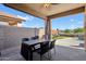 Covered patio area with dining table and chairs overlooking the pool and yard at 12425 W Jefferson St, Avondale, AZ 85323