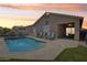 Backyard pool area with outdoor seating, covered patio, and sunset sky at 12425 W Jefferson St, Avondale, AZ 85323