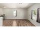 A freshly painted empty living room with new flooring offers a door and window at 1424 S Bonarden Ln, Tempe, AZ 85281
