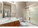 Bathroom with oak cabinets, mirror, tub/shower with glass doors at 1690 E Desert Breeze Ct, Casa Grande, AZ 85122