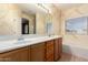 Well-lit bathroom featuring double sinks, soaking tub, and warm colors at 1690 E Desert Breeze Ct, Casa Grande, AZ 85122