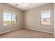 Bedroom features neutral walls and carpet, ceiling fan, and view to the backyard at 1690 E Desert Breeze Ct, Casa Grande, AZ 85122