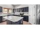 Modern kitchen with stainless steel appliances, marble countertop, and an island cooktop at 1690 E Desert Breeze Ct, Casa Grande, AZ 85122