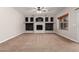 Living room features a fireplace, built-in shelving, a ceiling fan, and neutral carpeting at 1690 E Desert Breeze Ct, Casa Grande, AZ 85122