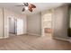 Large bedroom with carpet flooring, overhead fan, and view to the ensuite bath at 1690 E Desert Breeze Ct, Casa Grande, AZ 85122
