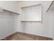 Spacious walk-in closet with white walls, neutral carpet and simple shelving with wooden closet rods at 1690 E Desert Breeze Ct, Casa Grande, AZ 85122
