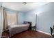 Cozy bedroom featuring laminate floors, a large window with vertical blinds, and an updated ceiling fan at 1736 E Villa Maria Dr, Phoenix, AZ 85022