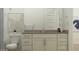 Well-lit bathroom with neutral colors featuring a framed mirror, white cabinets, and gray countertops at 17551 W Victory St, Goodyear, AZ 85338