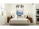 Inviting bedroom with a decorative light fixture and ensuite laundry behind a sliding door at 17551 W Victory St, Goodyear, AZ 85338