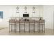 Elegant kitchen bar with four stylish stools and modern lighting fixtures above at 17551 W Victory St, Goodyear, AZ 85338