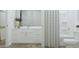 This bright bathroom features a white vanity and toilet, with a shower and tub at 17563 W Victory St, Goodyear, AZ 85338