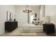 The bedroom has neutral tones, stylish light fixture, dresser and closet at 17563 W Victory St, Goodyear, AZ 85338