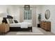 This serene bedroom showcases a black bed frame, wooden dresser, and stylish lighting, perfect for relaxation at 17563 W Victory St, Goodyear, AZ 85338