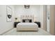 Bright primary bedroom with a gray upholstered bed frame, and side tables with lamps at 17563 W Victory St, Goodyear, AZ 85338