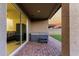 The back patio features a gray jacuzzi, brick flooring, and sliding glass doors that lead to the interior living area at 17813 W Pinnacle Vista Dr, Surprise, AZ 85387