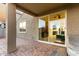 The back patio features a gray jacuzzi, brick flooring, and sliding glass doors that lead to the interior living area at 17813 W Pinnacle Vista Dr, Surprise, AZ 85387