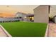 The backyard features an artificial turf lawn, brick-lined edges, and an exterior view of the home with a jacuzzi at 17813 W Pinnacle Vista Dr, Surprise, AZ 85387