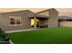 The backyard features an artificial turf lawn, brick-lined edges, and an exterior view of the home with a jacuzzi at 17813 W Pinnacle Vista Dr, Surprise, AZ 85387