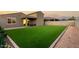 The backyard features an artificial turf lawn, brick-lined edges, and an exterior view of the home with a jacuzzi at 17813 W Pinnacle Vista Dr, Surprise, AZ 85387