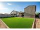 A spacious backyard featuring artificial turf, a covered patio, and brick pavers, perfect for outdoor living at 17813 W Pinnacle Vista Dr, Surprise, AZ 85387