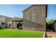 An inviting backyard showcasing artificial turf, a covered patio, and seamless indoor-outdoor living at 17813 W Pinnacle Vista Dr, Surprise, AZ 85387