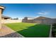 A beautifully landscaped backyard featuring artificial turf and a brick-lined patio area at 17813 W Pinnacle Vista Dr, Surprise, AZ 85387
