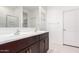 Bathroom showcasing double sinks with a dark wood vanity and a large mirror at 17813 W Pinnacle Vista Dr, Surprise, AZ 85387