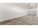 A spacious garage with an automatic door and concrete flooring offers plenty of room for vehicles and storage at 17813 W Pinnacle Vista Dr, Surprise, AZ 85387