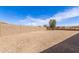 Spacious backyard with gravel and privacy wall in a desert setting at 19887 N Herbert Ave, Maricopa, AZ 85138