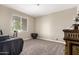 Bright, carpeted bedroom with a large window and neutral wall color at 19887 N Herbert Ave, Maricopa, AZ 85138